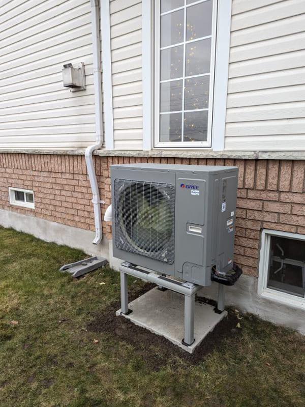 Aire One East technician assessing a heat pump water heater install in a Durham Region home