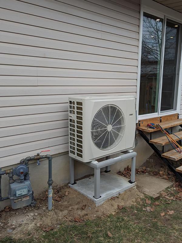 Aire One East technician installing a new air conditioner at a Whitby area home