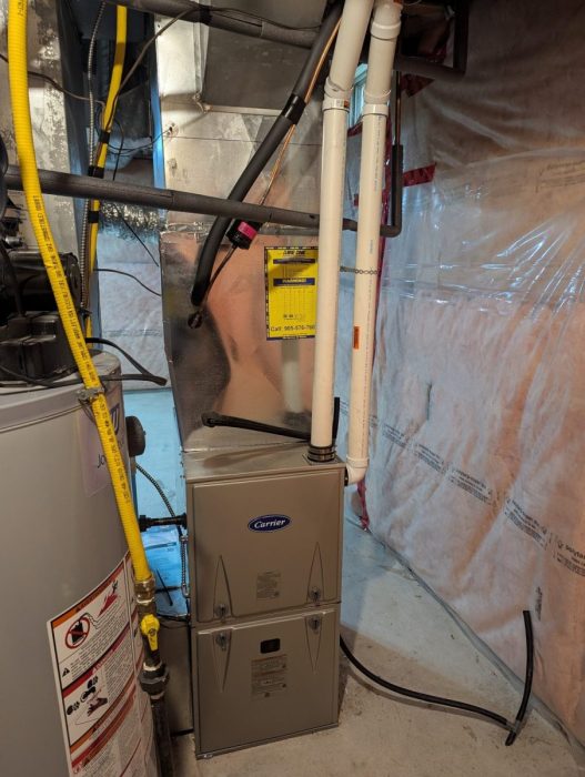 Carrier high-efficiency furnace installed in a basement beside the water heater
